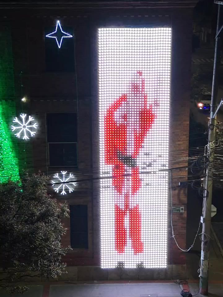 Dos secciones contiguas de pantalla LED encendidas sobre la fachada