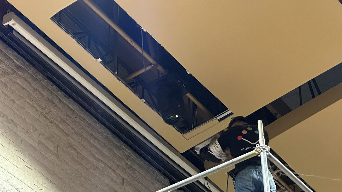 Técnico trabajando en alturas sobre la estructura del cielo raso del escenario