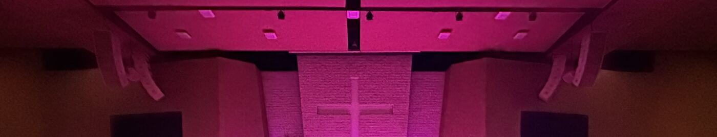 Lavado de color magenta sobre el muro del altar desde las luminarias cenitales